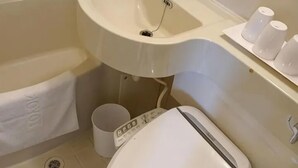 Un baño con lavamanos blanco, inodoro y toallero.