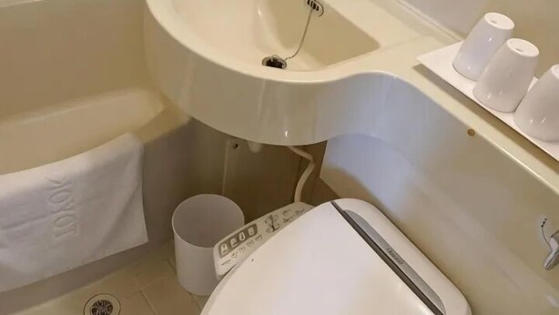 A bathroom with a white sink, toilet, and a towel rack. - Ibis Budget Phnom Penh Riverside (Phnom Penh)