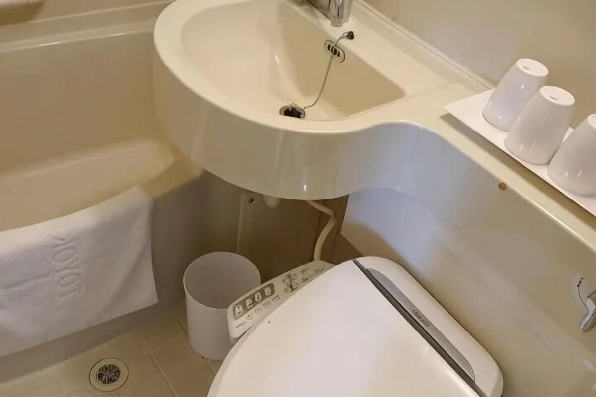 Une salle de bain avec un lavabo blanc, des toilettes et un porte-serviettes.