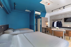 Une chambre d’hôtel moderne, dotée d’un grand lit, d’un bureau et d’une télévision.