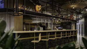 A bar area with shelves of bottles and glasses, a guitar, and bar stools. - Adagio Kyiv Beresteiska (Kyiv)