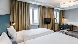 A hotel room with two beds, a TV, a desk, and a chair. - Adagio Kyiv Beresteiska (Kyiv)