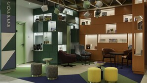 A modern coffee shop with a green and brown color scheme, featuring a counter, seating area, and a bookshelf. - Adagio Kyiv Beresteiska (Kyiv)