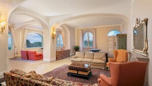 A spacious living room with high ceilings, arched windows, and a view of the outdoors. - Tenuta Bagni de Consoli 24 (Bertinoro)