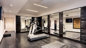 A modern gym with a treadmill, weight machines, and a mirror wall. - Tenuta Bagni de Consoli 24 (Bertinoro)