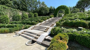 A stone staircase ascending a hill, surrounded by manicured hedges and trees. - Tenuta Bagni de Consoli 24 (Bertinoro)