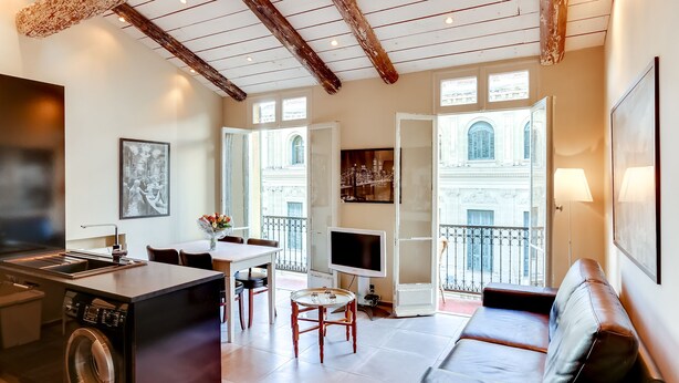 A modern living space with a kitchen, dining area, and seating area.