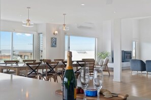 Un espace repas moderne avec une grande table, des chaises et une bouteille de champagne.