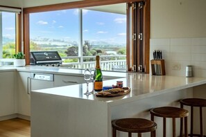 Una cocina con una isla grande, una computadora portátil, copas de vino y una botella de champán.