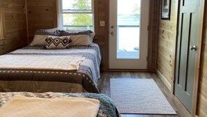 Een gezellige slaapkamer met een bed, een deur en een raam.