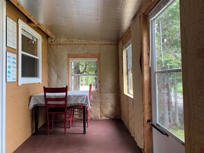 A room with a table and chairs, a window, and insulation on the walls.
