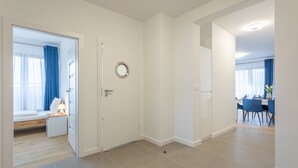 A modern hotel room with a bed, bedside table, and a view of the dining area. - Vacation apartment by the sea, vacation on the island of Usedom, Apartment PLATAN V (Świnoujście)