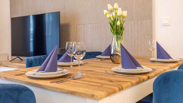 A dining table set with plates, glasses, and a vase of flowers. - Vacation apartment by the sea, vacation on the island of Usedom, Apartment PLATAN V (Świnoujście)