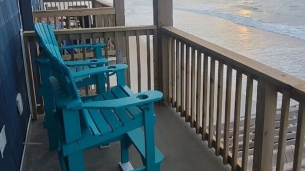 A wooden deck with turquoise Adirondack chairs overlooking the ocean. - Ocean Getaway - Ocean Front Condo (North Topsail Beach)