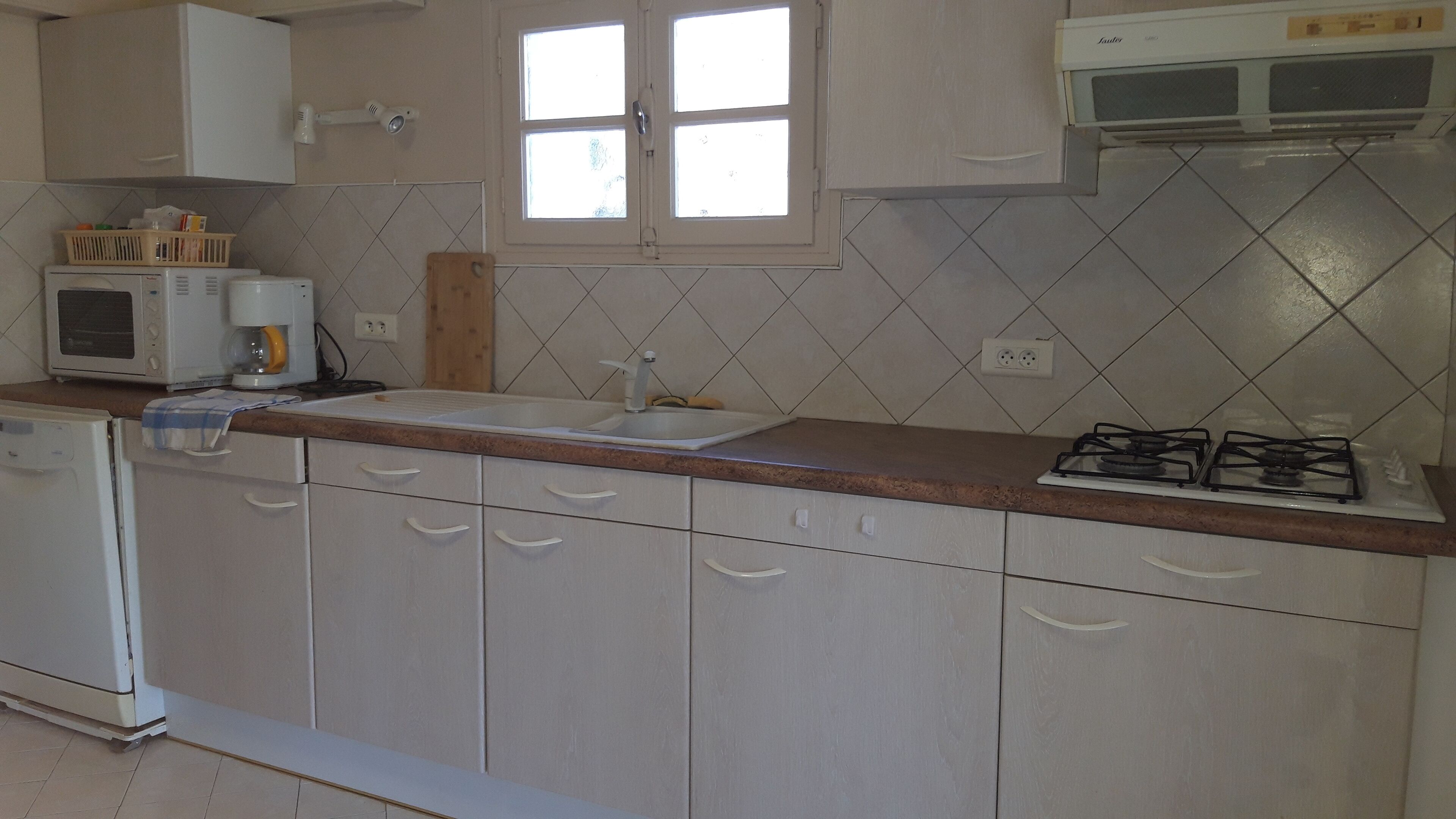 A kitchen with a microwave, stove, sink, and cabinets.