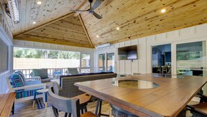 A spacious outdoor area with a wooden ceiling, a large bar area, and seating arrangements.