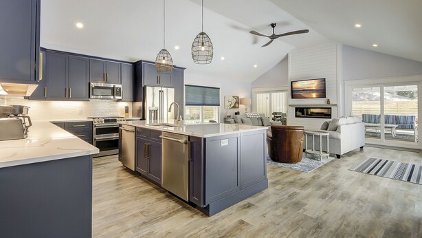 A modern kitchen with dark cabinets, stainless appliances, and a central island.