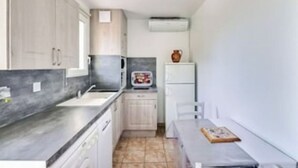 Una cocina compacta equipada con microondas, estufa y refrigerador pequeño.