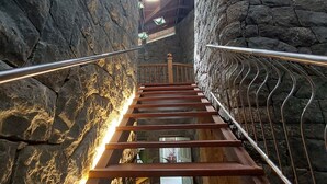 A staircase with stone walls and wooden steps, leading to a higher level. - Mystic Mayapott Thekkady (Idukki)