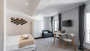 Una habitación de hotel moderna con una cama, un escritorio y un televisor.