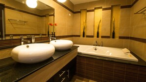 A modern bathroom with two sinks, a large bathtub, and a mirror.