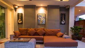 A modern living room with a sectional sofa, a glass coffee table, and decorative wall art.