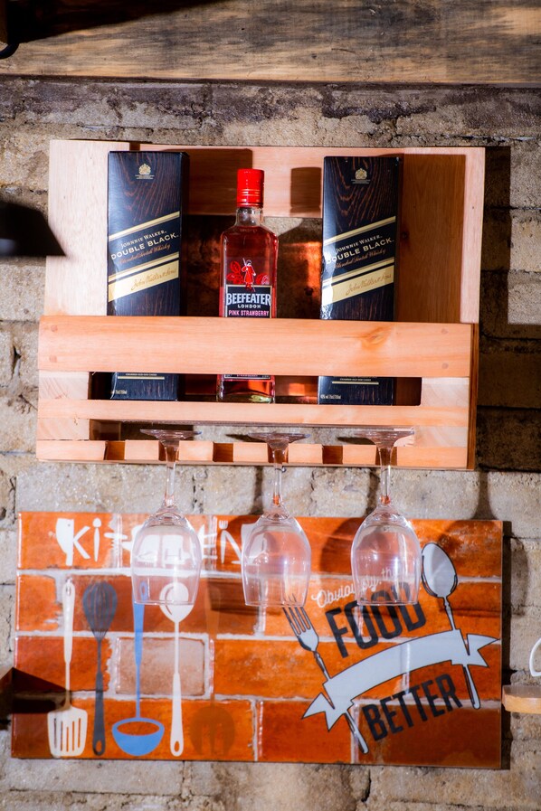 A wooden box with two bottles of Johnnie Walker Double Black whisky and a bottle of BeefEater Pink Strawberry London gin. Below, a kitchen-themed sign reads "Food Better" with utensils and glasses.