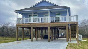 A two-story house with a balcony, wooden deck, and a garage. - Hackberry Hideaway III (Hackberry)