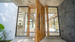 Un interior moderno con grandes puertas de cristal, techo de hormigón y pared de piedra.