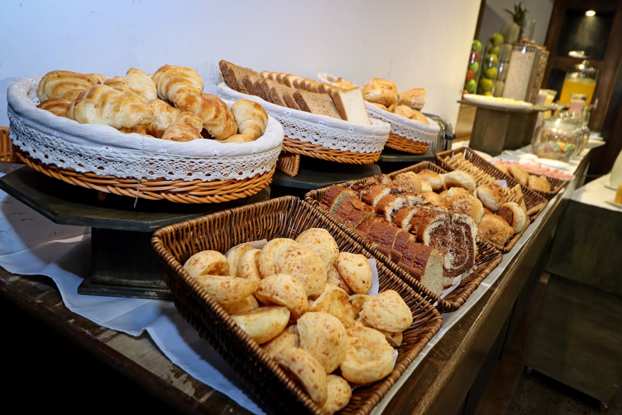 A buffet with various breads and pastries.