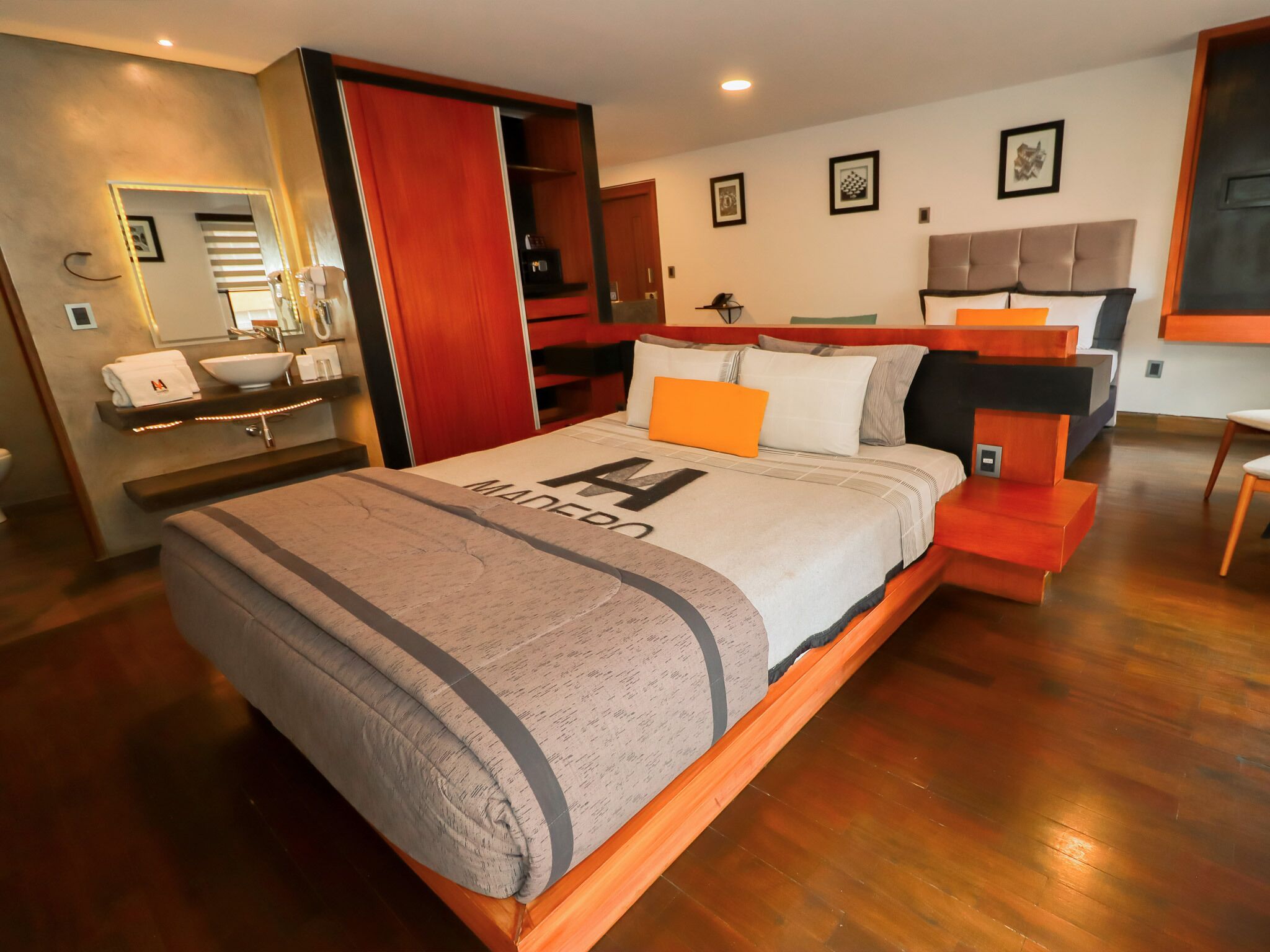 A modern bedroom with a large bed, wooden headboard, and a built-in wardrobe.