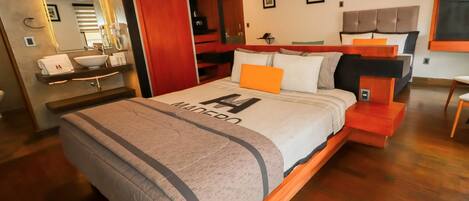 A modern bedroom with a large bed, wooden headboard, and a built-in wardrobe.