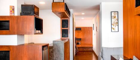 A modern kitchen with wooden cabinetry, a built-in microwave, and a grey countertop.