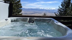 Relax in a hot tub on a deck with breathtaking mountain views.
