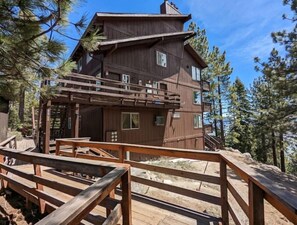 Experience the rustic charm of this cabin, offering a balcony with a forest view from its wooden deck.