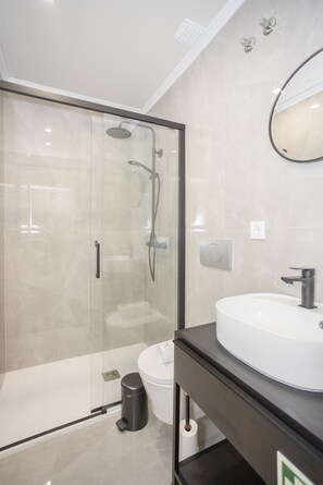 A modern bathroom with a glass-enclosed shower, a white sink, and a toilet. - Liiiving in Porto-Uptown Pearl Apartment (Porto)