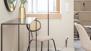 A modern room with a desk, chair, and a large mirror. There is a window with a view of the outside, a floor lamp, and a small table with a vase. - Liiiving in Porto-Uptown Pearl Apartment (Porto)