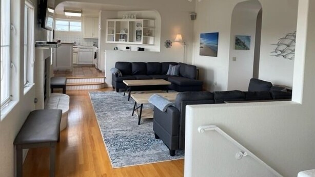 Un salon moderne avec un canapé d’angle, une table basse et un téléviseur fixé au mur.