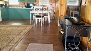 A wooden interior with a kitchen, dining area, and a television. - Waterfront Cabin with lighted fishing pier (Matagorda)