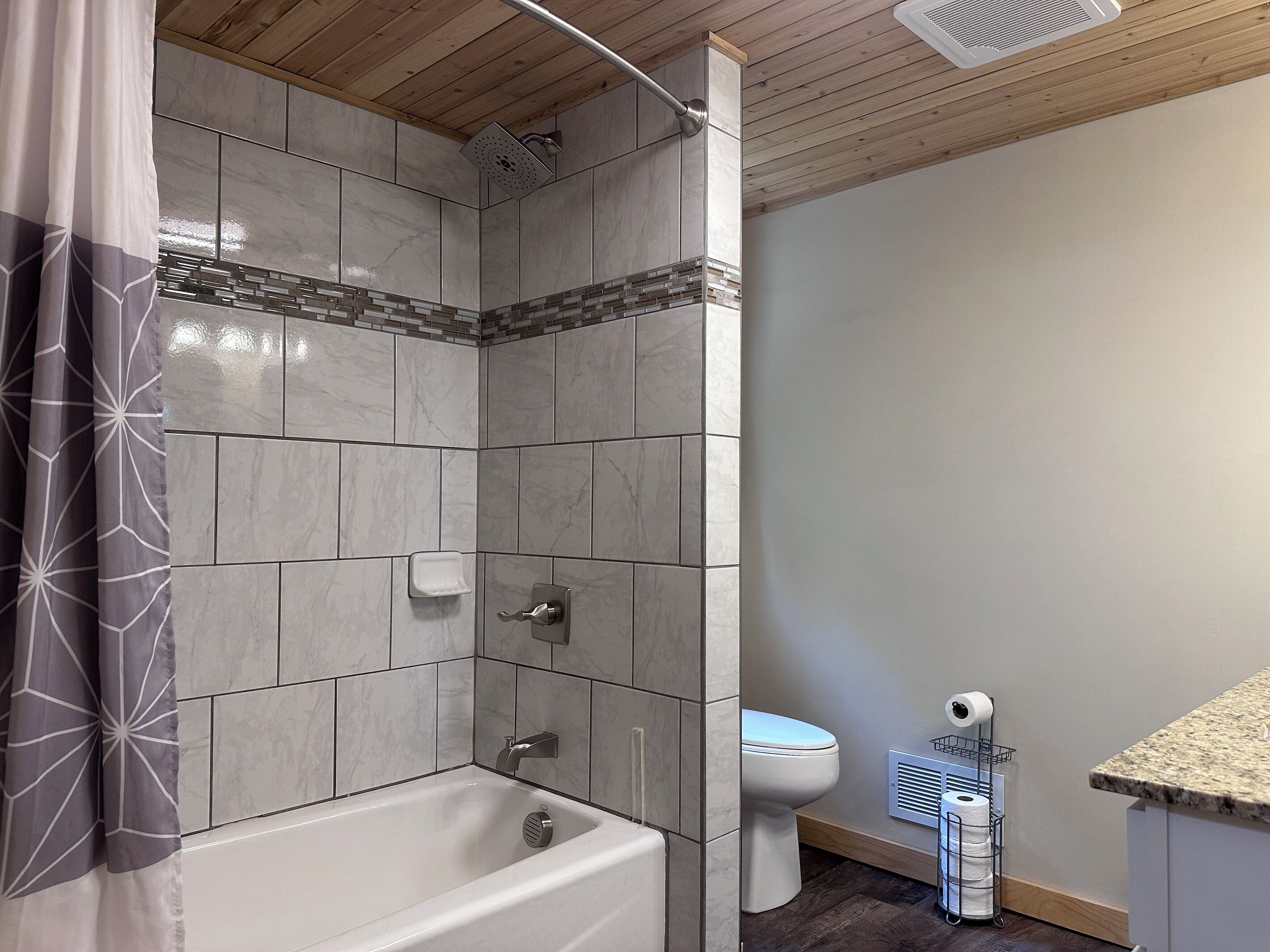 Une salle de bain équipée d’une baignoire, d’une douche, de toilettes et d’un porte-serviettes.