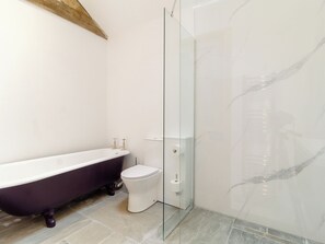 A bathroom with a freestanding bathtub, a toilet, and a glass-enclosed shower. - 3 bedroom accommodation in Watton (Watton)