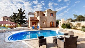 A stone building with a swimming pool, outdoor seating, and a pergola. - Rural Stone Villa with private pool and mountain views near local sandy beaches! (Paleloni)