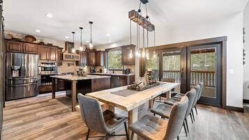 A spacious kitchen with a large island, modern appliances, and a dining area with chairs.