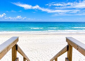 A beach with wooden benches and a clear view of the ocean.