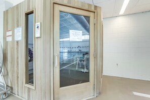 Enter a room with a large glass door offering a view of the interior, featuring a ceiling fan and a metal cart.