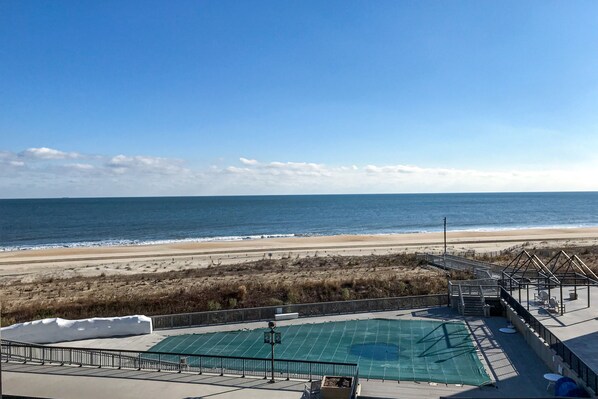 Enjoy the ocean view from the covered outdoor area with a pool, seating, and deck.