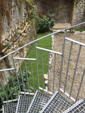 A metal staircase with a metal railing leading to a stone wall. - Le Tavae (Cauterets)