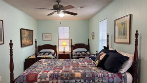 A bedroom with two beds, a ceiling fan, and a window with blinds. - Secluded cabin - 10 miles from Fredericksburg! (Fredericksburg)