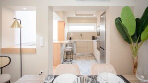 A modern kitchen with a dining area, including a table set for two with wine glasses.