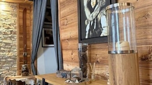 Ein Holzinterieur mit einem Esstisch, einem gerahmten Bild und einem dekorativen Glasbehälter.
